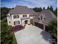 Stunning two-story home with a three car garage, balcony, manicured lawn, and beautiful landscaping at 20635 Queensdale Dr, Cornelius, NC 28031