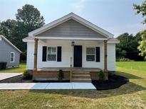 Charming single story home featuring a cozy front porch and fresh landscaping at 210 Marshall St, Rock Hill, SC 29730
