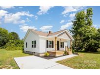 Charming single-story home with white siding, a welcoming front porch, and a freshly poured concrete driveway at 210 Marshall St, Rock Hill, SC 29730