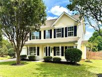 Charming two-story home with manicured lawn, lush landscaping, and welcoming front porch at 2242 Shumard Cir, Indian Trail, NC 28079