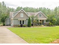 Charming two-story home featuring manicured lawn, lush landscaping, and inviting curb appeal in a wooded neighborhood at 237 Garvin Rd, McConnells, SC 29726