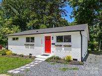 Charming home featuring a bright red door, brick exterior, and well-manicured landscaping at 2600 Alleghany St # 10, Charlotte, NC 28208