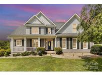 Charming two-story home featuring a covered front porch and professionally landscaped yard at 3068 Green Acres Ln, Claremont, NC 28610
