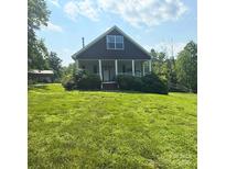 Charming home with a front porch, lush green lawn, and mature trees, offering a peaceful and inviting atmosphere at 3659 Vashti Rd, Taylorsville, NC 28681