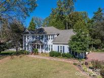 Charming two-story home with a well-manicured front yard and beautiful mature trees at 3664 Gaston Day School Rd, Gastonia, NC 28056