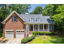 Charming two-story brick home with a well-manicured lawn, attached garage, and inviting front porch at 4605 Sarandon Ct, Charlotte, NC 28215