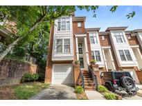 Beautiful brick townhome featuring a single-car garage, private entrance, and mature landscaping at 4854 S Hill View Dr, Charlotte, NC 28210