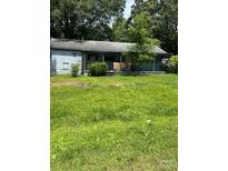 Cozy single-story home with a covered front porch and mature landscaping at 4914 Friendship Dr, Matthews, NC 28105