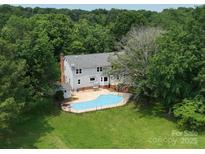 Expansive backyard with a private in-ground pool and mature trees surrounding the property at 5632 Zion Church Rd, Concord, NC 28025