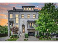 Elegant townhome featuring a brick facade, dormer windows, and a well-manicured front yard at 622 Mattie Rose Ln, Charlotte, NC 28204