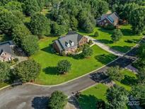 Expansive aerial view of a red brick home surrounded by lush greenery and well-manicured lawns in a neighborhood at 908 Haddonfield Dr, Fort Mill, SC 29708