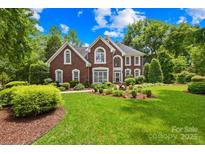 Charming brick two-story home with a well-manicured lawn and beautiful landscaping at 9514 Hayenridge Ct, Huntersville, NC 28078