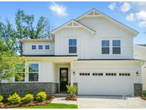 Stunning two-story home with white siding, stone accents, lush landscaping, and an attached two-car garage at 9846 Quercus Ln, Huntersville, NC 28078