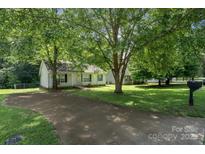 Charming single-story home featuring a driveway and well-maintained front yard with mature trees at 1013 Ashwood Pl, Salisbury, NC 28146