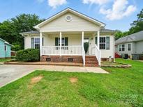 Charming one-story home featuring a covered front porch, white railings, and classic curb appeal at 1015 Rhode Island Ave, Kannapolis, NC 28083