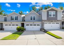 Townhome exterior with gray siding, stone accents, and a two-car garage at 1022 Maltby St, Charlotte, NC 28217