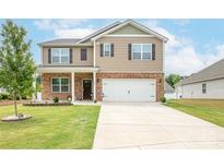 Inviting two-story home featuring a brick-and-siding facade, attached two car garage, and well-maintained lawn at 128 Hickory Ridge Dr, Locust, NC 28097