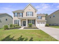Charming two-story home with black shutters, lush landscaping and a two car garage at 128 Yellowbell Rd, Mooresville, NC 28117
