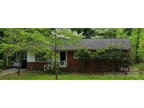 Charming brick home with mature trees and inviting front porch in a quiet, established neighborhood at 1332 Midwood Dr, Gastonia, NC 28052
