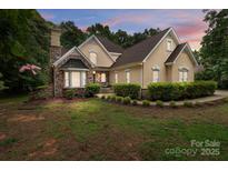 Charming stucco home featuring a stone facade, manicured landscaping, and inviting curb appeal at 165 Futrell Lndg, New London, NC 28127