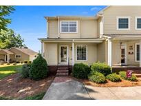 Inviting two-story home with yellow siding, a covered porch, and manicured landscaping creating great curb appeal at 1670 Robins Nest Ct # D, Gastonia, NC 28054