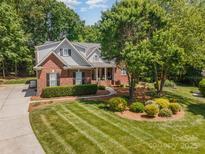 Charming brick home boasts lush landscaping, mature trees, and a well-manicured lawn for curb appeal at 2804 Pulaski Dr, Monroe, NC 28110