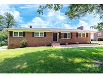 Charming brick home with a well-maintained lawn and classic architectural details at 306 2Nd Avenue Ne Pl, Conover, NC 28613