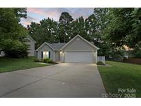 Charming single-story home featuring a well-maintained lawn, attached garage, and inviting curb appeal at 3114 Pine Pointe St, Matthews, NC 28104
