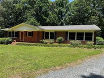 Charming brick home featuring a well-manicured lawn and a classic ranch-style design at 34393 Springdale Dr, New London, NC 28127