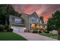 Charming two-story home with a welcoming front porch, well-manicured lawn, and a two-car garage at sunset at 3701 Methodist Church Ln, Waxhaw, NC 28173