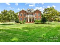 Beautiful brick home with manicured lawn and lush landscaping at 3706 Song Sparrow Dr, Matthews, NC 28104