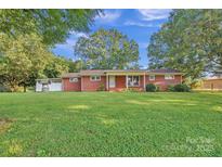 Charming one-story brick home with a well and a large green lawn under a sunny blue sky at 37156 Southside Rd, Albemarle, NC 28001