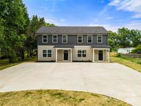 New construction of a two story duplex featuring a large driveway and landscaping at 445 Faith Sw Dr, Concord, NC 28027