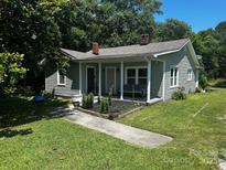 Charming home featuring a cozy front porch and a well-maintained, green lawn at 448 Belk St, Lancaster, SC 29720