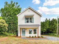 Charming two-story home featuring a light exterior, blue door, and a landscaped front yard, perfect for curb appeal at 5306 Lee Massey Rd, Waxhaw, NC 28173