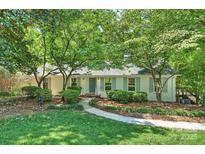 Charming one-story home with manicured lawn, inviting walkway, and mature trees providing ample shade at 6150 Rocky Falls Rd, Charlotte, NC 28211