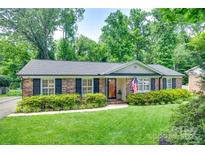 Charming brick home with a well-manicured lawn and lush landscaping at 7026 Tabor Ln, Charlotte, NC 28211