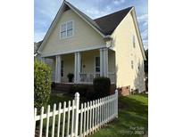 Charming home with a welcoming porch and a neat white picket fence, surrounded by lush greenery at 7344 Gilead Rd, Huntersville, NC 28078