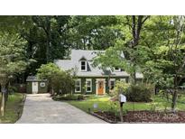 Charming home featuring a colorful door, lush landscaping, and a welcoming driveway at 7639 Winterset Dr, Charlotte, NC 28270