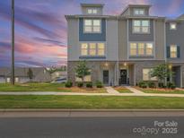 Charming townhome exterior featuring a well-maintained lawn, brick accents, and a welcoming entrance at 8332 Waxhaw Hwy, Waxhaw, NC 28173