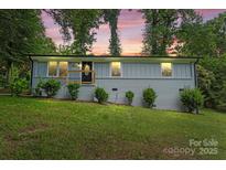 Twilight view of updated single story home in the evening, complemented by mature trees at 10514 Harbor Dr, Charlotte, NC 28214