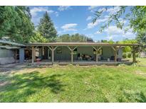 The backyard features a covered patio, offering shade and space for outdoor seating at 107 Skyuka Rd, Statesville, NC 28677