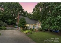 Charming one-story home with mature trees, manicured lawn and blue accents creating curb appeal at 111 Beacon Hills Dr, Gastonia, NC 28056