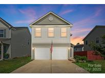 Charming two-story home with a two-car garage and an American flag waving in front at 12522 Palomino Dr, Midland, NC 28107
