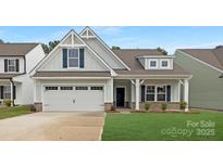 Inviting home featuring a two-car garage, charming porch, and well-maintained lawn at 170 Aspire Cir # 31, Wingate, NC 28174