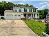 Charming two-story white home with a two-car garage, red brick accents, and a beautifully landscaped yard at 2008 Bantry Ln, Charlotte, NC 28262