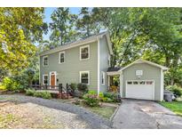 Charming two-story home boasts a quaint fenced yard, inviting entrance, and attached garage at 2034 Lanier Ave, Charlotte, NC 28205