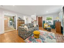 Inviting living room features a floral sofa, hardwood floors, and stylish decor, creating a cozy atmosphere at 2034 Lanier Ave, Charlotte, NC 28205