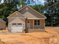 Charming single-Gathering home with a one-car garage and a covered front porch, set against a backdrop of lush green trees at 2560 S Jake Alexander S Blvd, Salisbury, NC 28146