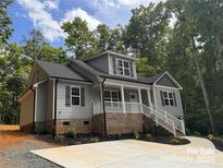 Charming exterior elevation of a two-story home with gray siding and a welcoming front porch at 292 Manchester Rd, Mount Gilead, NC 27306